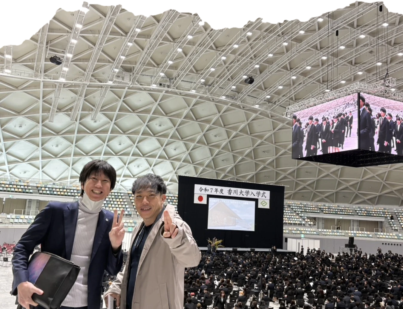 香川大学の入学式の会場で、並んでピースサインをする石井さんと運営メンバー