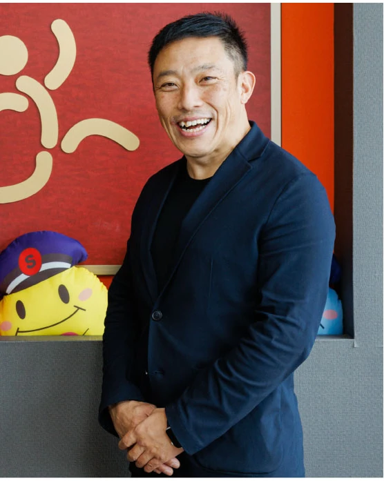 ネイビーのジャケット姿で、声を出して笑う石井さん