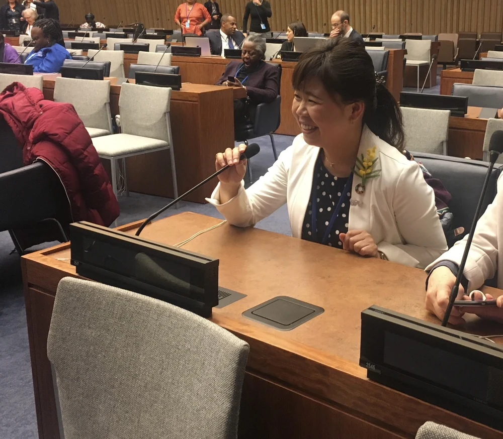 国連の会議場で、マイクを手に笑顔の石浜さん